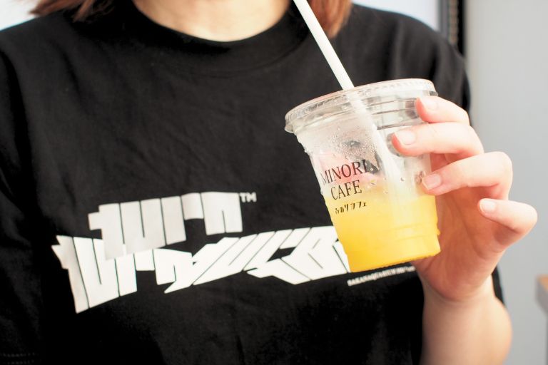 サカナクションのTシャツを着てみのりカフェ元気市広島店の柑橘ミックスドリンクを飲んでいるところ