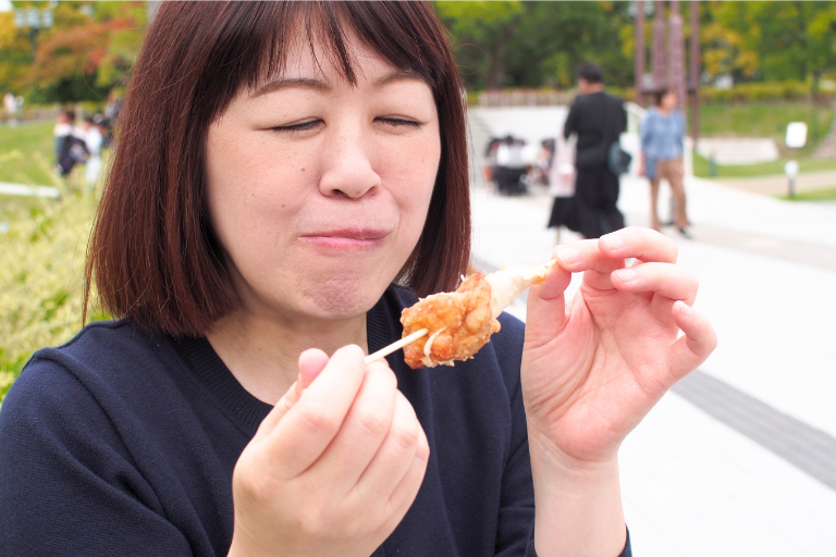 広島パンフェスタで買ったくろべえの唐揚げを食べているところ