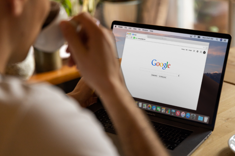 ノートパソコンでコーヒーを飲みながらGoogle検索をしているところ