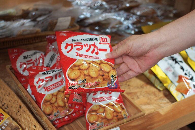 スパ羅漢の産直市売店に並ぶあたり前田のクラッカーを見せているところ